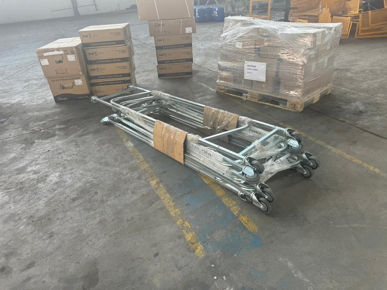Blue tri-axle flatbed trailer loaded with galvanised steel pipes